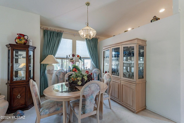 dining room featuring light carpet and a notable chandelier