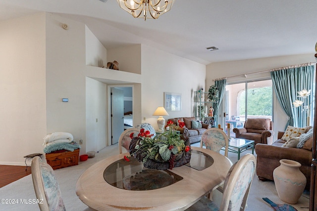 dining room with an inviting chandelier, lofted ceiling, and light hardwood / wood-style flooring