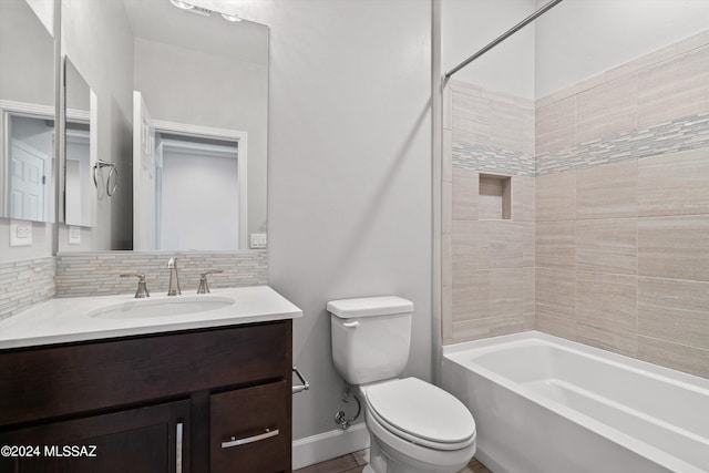 full bathroom with tiled shower / bath, vanity, toilet, and tasteful backsplash