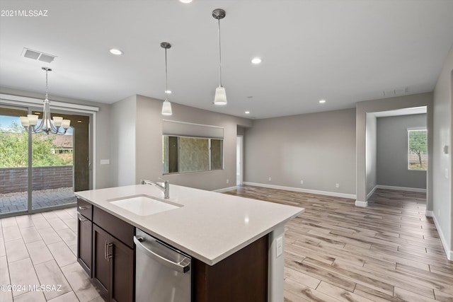 kitchen with dishwasher, pendant lighting, light wood-type flooring, an inviting chandelier, and sink