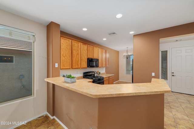 kitchen with light tile patterned flooring, kitchen peninsula, black appliances, an inviting chandelier, and decorative light fixtures