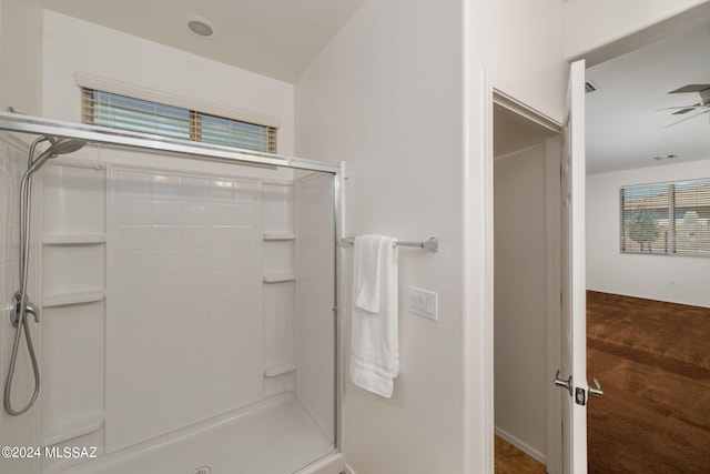 bathroom featuring a shower with door and ceiling fan