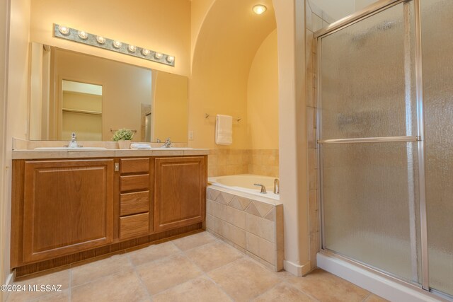 bathroom featuring tile patterned flooring, vanity, and plus walk in shower