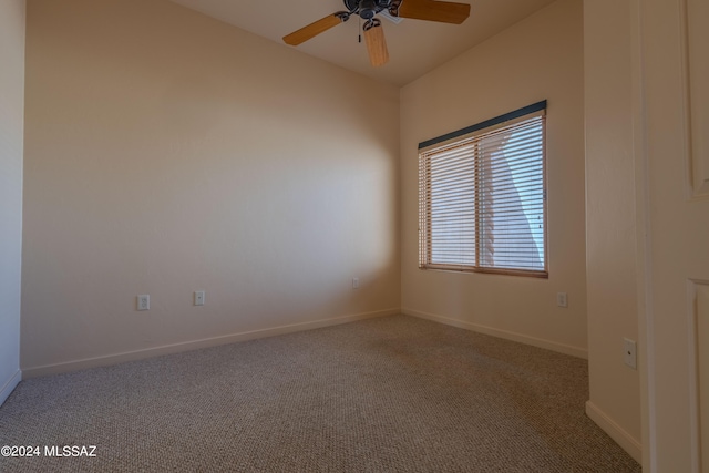 carpeted spare room with ceiling fan