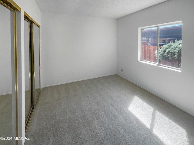 unfurnished bedroom featuring a textured ceiling and carpet floors