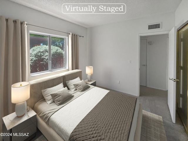 carpeted bedroom featuring a textured ceiling