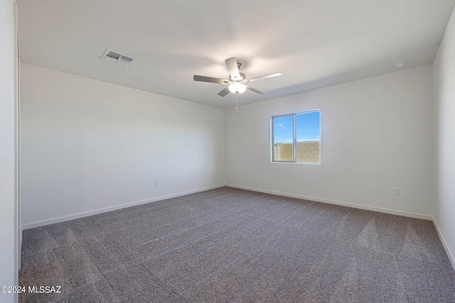 empty room with dark carpet and ceiling fan