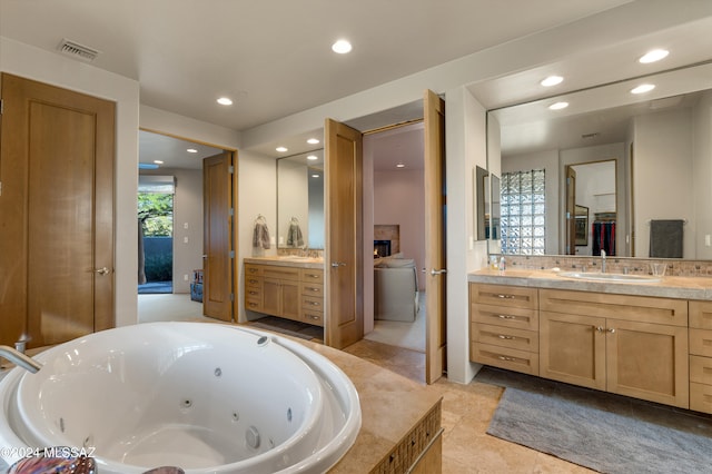 bathroom with vanity, a fireplace, tile patterned floors, and tiled bath