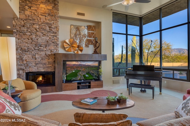 living room featuring a high ceiling, a stone fireplace, and carpet floors