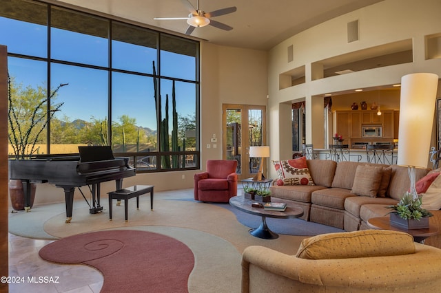 living room featuring ceiling fan and a towering ceiling