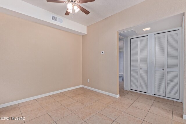 unfurnished bedroom with ceiling fan and light tile patterned flooring