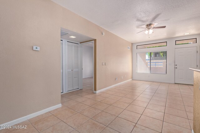 tiled spare room featuring ceiling fan and a textured ceiling