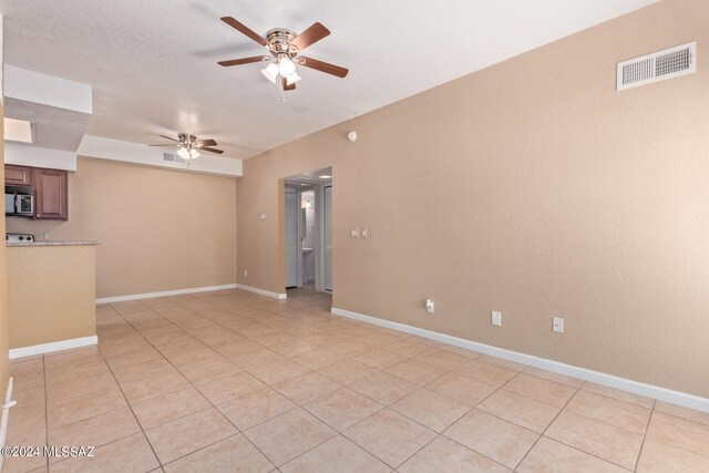 empty room with light tile patterned flooring and ceiling fan