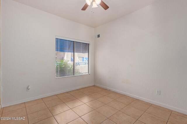 tiled empty room featuring ceiling fan