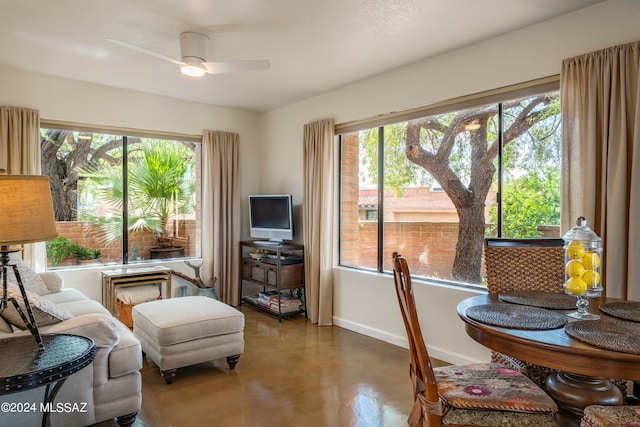 interior space with a wealth of natural light, concrete floors, and ceiling fan