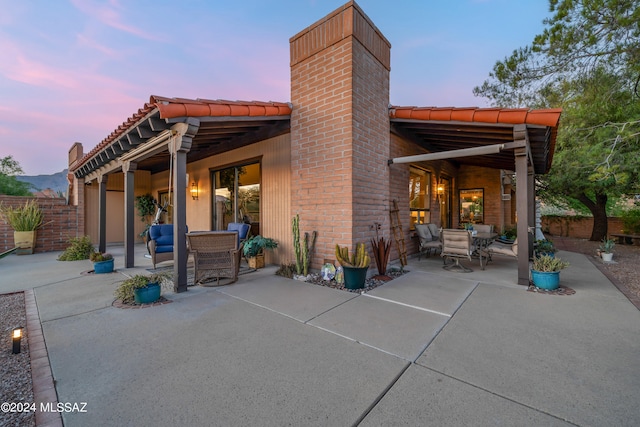 back house at dusk with a patio