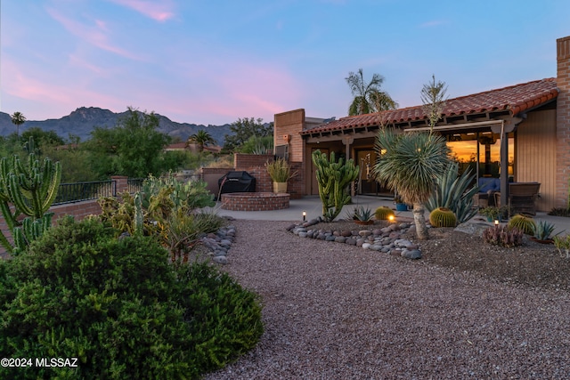 yard at dusk with a patio and a mountain view