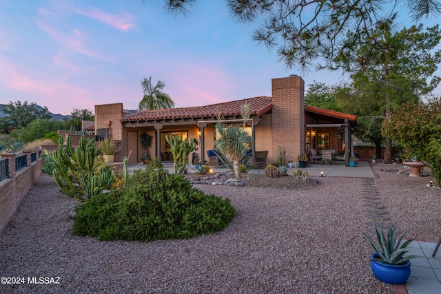 back house at dusk with a patio