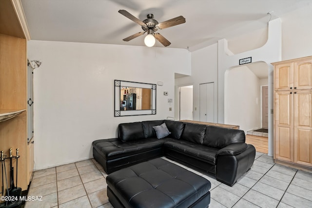 tiled living room featuring ceiling fan and high vaulted ceiling