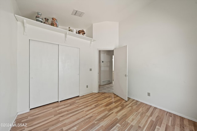 unfurnished bedroom with a closet and light hardwood / wood-style floors