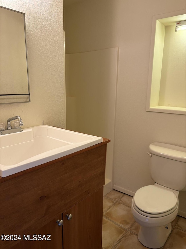 bathroom with vanity, tile patterned floors, and toilet