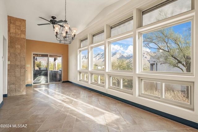 interior space with a mountain view, ceiling fan with notable chandelier, and vaulted ceiling