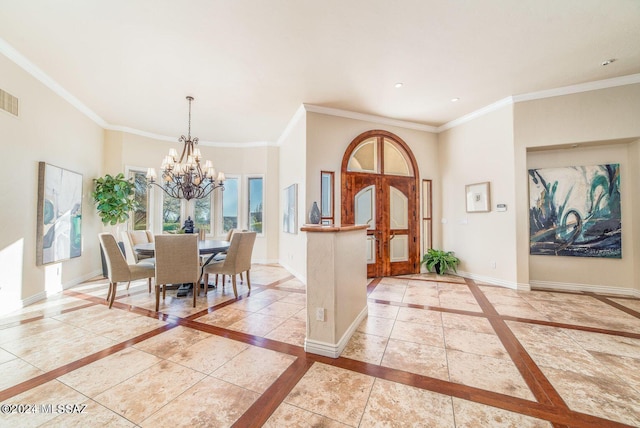 entryway with ornamental molding and a chandelier