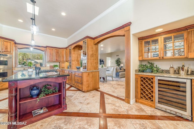 kitchen with a kitchen island, stainless steel double oven, hanging light fixtures, ornamental molding, and wine cooler