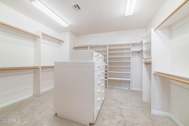 walk in closet with light colored carpet