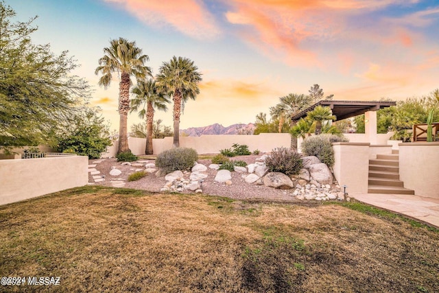 yard at dusk featuring a mountain view