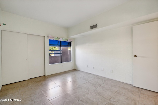 unfurnished bedroom with light tile patterned floors and a closet