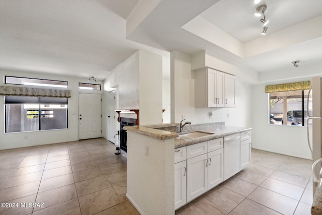 kitchen with white cabinetry, sink, white dishwasher, and light stone countertops