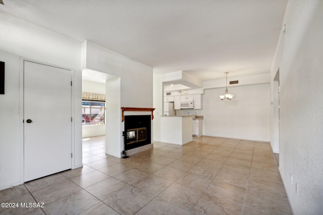 unfurnished living room with a textured ceiling and light tile patterned floors