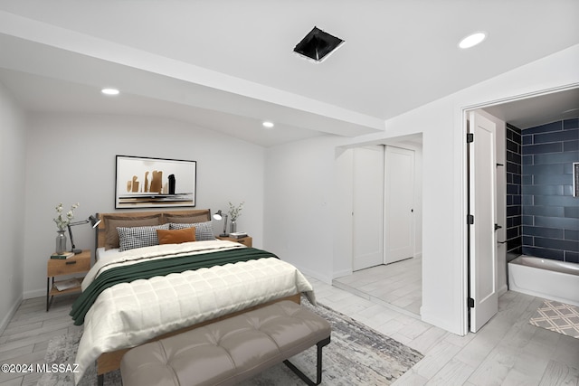 bedroom with light wood-type flooring, a closet, and lofted ceiling