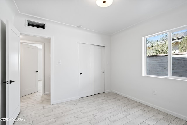 unfurnished bedroom with light hardwood / wood-style floors and a closet