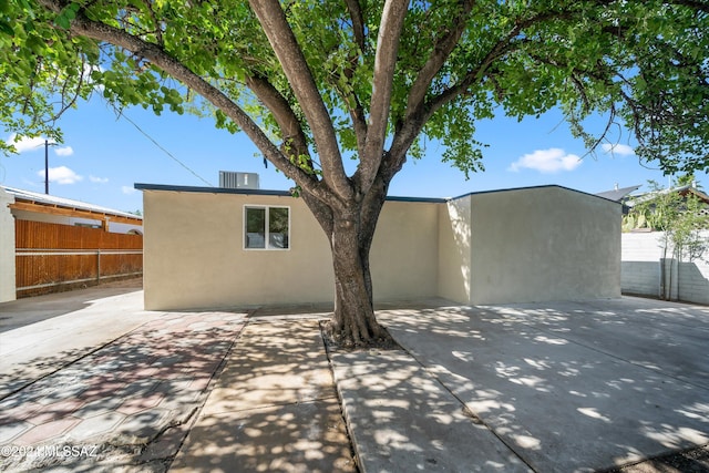 back of property with cooling unit and a patio area