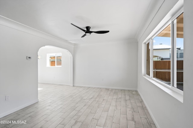 spare room with ceiling fan, a healthy amount of sunlight, ornamental molding, and light hardwood / wood-style flooring