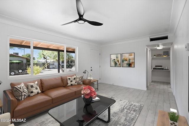 living room with light hardwood / wood-style floors, ceiling fan, and crown molding