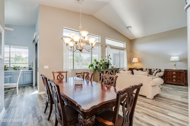 dining area with light wood-style flooring, a healthy amount of sunlight, visible vents, and a chandelier