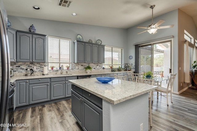 kitchen with wood finished floors, a ceiling fan, visible vents, gray cabinets, and a sink