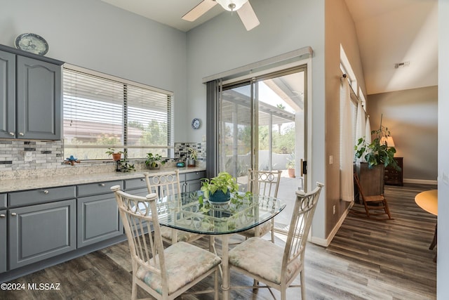 dining space featuring dark wood-type flooring, ceiling fan, and vaulted ceiling