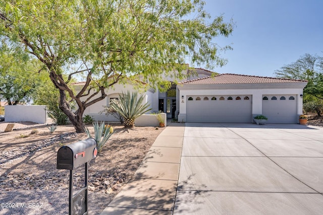 view of front of house featuring a tile roof, stucco siding, driveway, and an attached garage