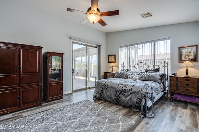 bedroom featuring access to outside, multiple windows, wood finished floors, and visible vents