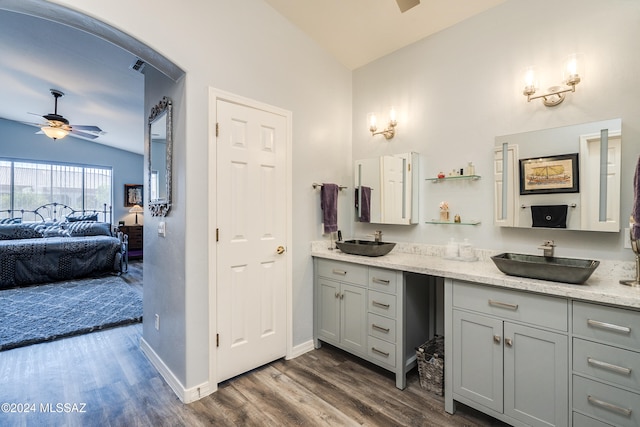 ensuite bathroom featuring vaulted ceiling, a ceiling fan, ensuite bathroom, and a sink