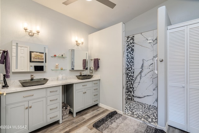 full bathroom featuring a sink, a closet, a marble finish shower, and double vanity