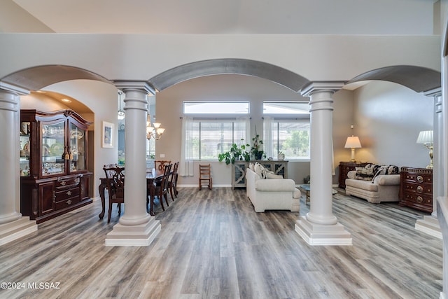 dining area featuring wood-type flooring and ornate columns