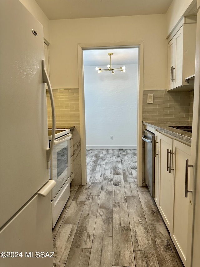 kitchen with white cabinets, white appliances, tasteful backsplash, a notable chandelier, and light hardwood / wood-style floors