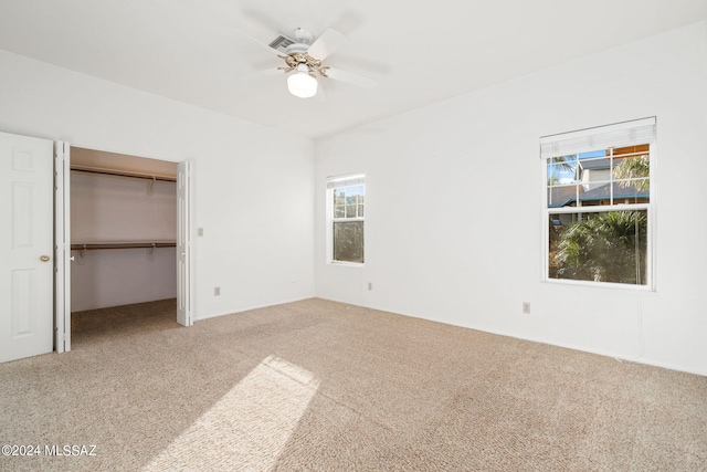 unfurnished bedroom featuring carpet floors, a closet, and ceiling fan