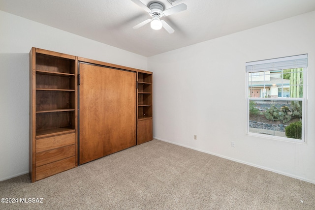 unfurnished bedroom with a closet, carpet, and ceiling fan