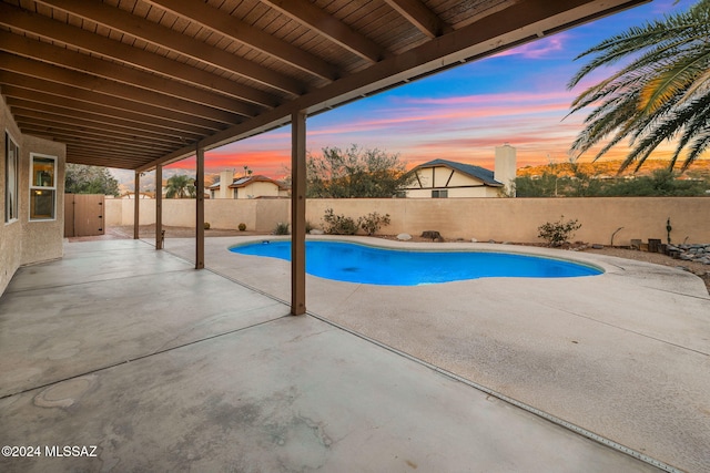 pool at dusk featuring a patio area